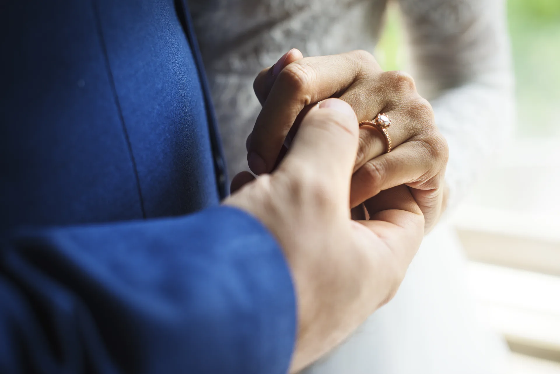 Mãos dos noivos com alianças durante cerimônia de casamento civil no Cartório Vieira